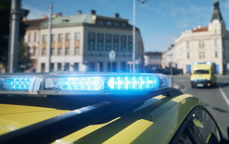 Close up of blue flashing light on top of an emergency vehicle with a second in the background. 